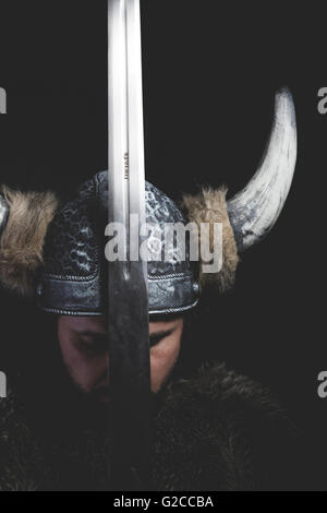 La guerre, guerrier viking avec épée en fer et un casque avec des cornes Banque D'Images