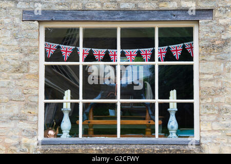 Cheval à bascule et union jack noir dans la fenêtre de l'Ancienne Poste boutique, Guiting Power, Gloucestershire, Angleterre Banque D'Images