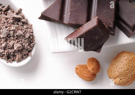 Les portions et les copeaux de chocolat avec amandes close up sur un récipient en porcelaine blanche sur un tableau blanc dans la cuisine. L'horizontale Banque D'Images