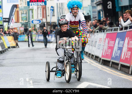 Pays de Galles Aberystwyth UK, vendredi 27 mai 2016 Des centaines de personnes prennent part à l'assemblée annuelle Cycle fest Aber de vélo autour de la fermeture des rues de la ville. Photo : KAI, un jeune garçon atteint de paralysie cérébrale, en concurrence dans la course sur son tricycle, aidé par un clown. Début de l'après-midi avec des courses pour les enfants de l'école, et jusqu'à une tempête spectaculaire le tonnerre et les éclairs, l'événement culminant dans la soirée avec des coureurs professionnels en compétition dans la série d'Izumi Poire Crédit photo : Keith Morris / Alamy Live News Banque D'Images