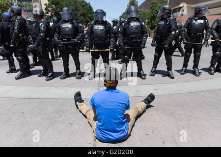 Fresno, Californie, USA. 27 mai, 2016. Une femme s'assoit en face de la ligne de la police à l'extérieur du Fresno Convention Center où Donald Trump vient d'organisé un rassemblement. Crédit : John Orvis/Alamy Live News Banque D'Images