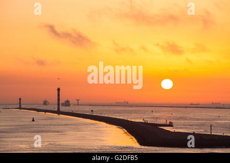 Jetée avec bateaux en silhouette en partant du port de Rotterdam Pays-Bas au coucher du soleil Banque D'Images