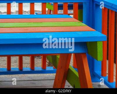 Bleu, rouge et vert peint balustrade et table de pique-nique en bois peint assis sur un pont dans les îles Turques et Caïques Banque D'Images