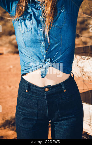 Mid-Section Portrait of Young Adult Woman Wearing Vintage shirt et jeans denim nouée Banque D'Images