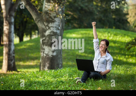 Excitée mature woman holding wining fist crier haut de bonheur avec coffre Banque D'Images