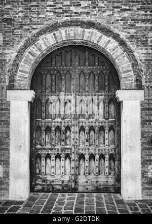 Entrée voûtée d'un palais médiéval avec porte en bois sculpté. Banque D'Images