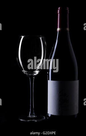 Bouteille de vin en verre vide et silhouette sur fond noir Banque D'Images