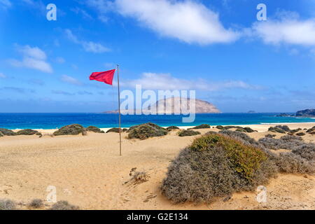 Drapeau rouge sur la plage de las Conchas, La Graciosa, Lanzarote, îles Canaries, Espagne Banque D'Images