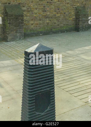 Trottoir à Londres avec un vieux mur de brique, les modèles sur le trottoir et d'une structure de type monolithe de granit noir Banque D'Images