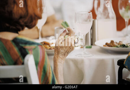 Femme plus âgée à table à manger Banque D'Images