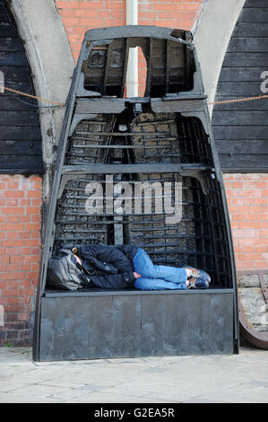 Brighton Sussex UK 29 mai 2016 - Un homme dort dans un vieux bateau de pêche tournée vers le début de ce matin sur le front de mer de Brighton que le temps devrait rester au chaud et ensoleillé pour le reste de la bank holiday weekend Crédit : Simon Dack/Alamy Live News Banque D'Images