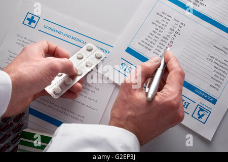 Médicaments de prescription des médecins et montrant de sang rapport avec les documents et des médicaments sur une table en verre blanc. L'horizontale Banque D'Images