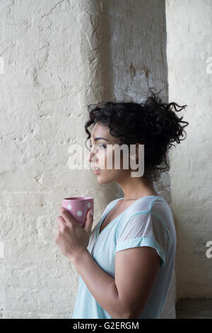 Worried woman drinking coffee à loin inquiet Banque D'Images