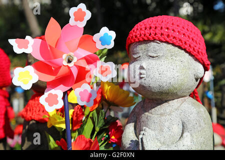 Statues Jizo et colorent un moulin jouets dans le Temple Zojoji jardin cimetière à Tokyo, Japon Banque D'Images