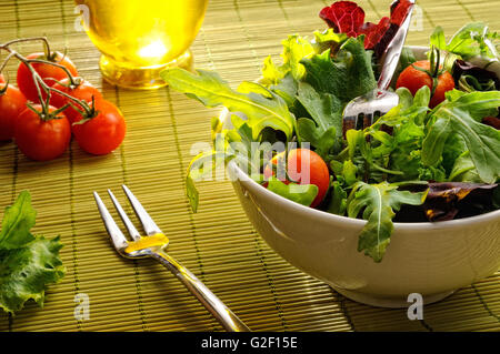 Dans un bol à salade sur nappe bambou avec fourchette et l'huile, front view Banque D'Images