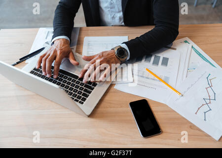 Close-up portrait of mans mains tapant sur l'ordinateur portable dans le bureau Banque D'Images