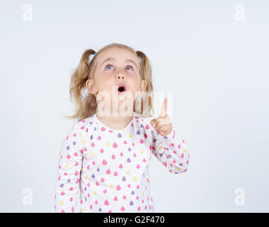 Little girl wearing orientée par l'index pour quelque part jusqu'isolated Banque D'Images