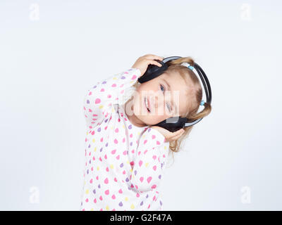 Little girl listening to music on headphones. Banque D'Images