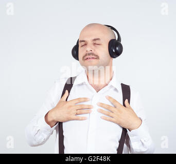 Homme chauve avec une moustache woman listening to music on headphones et chante Banque D'Images