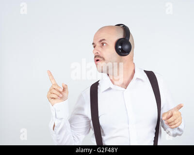 Homme chauve avec une moustache woman listening to music on headphones et chante Banque D'Images