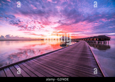 Résumé fond incroyable. Magnifique coucher de soleil couleurs dans les Maldives. Long jetty et de luxe, villas sur Banque D'Images