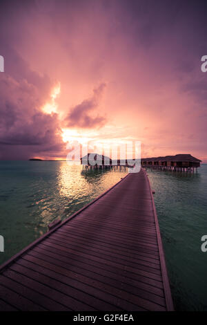 Résumé fond incroyable. Magnifique coucher de soleil couleurs dans les Maldives. Long jetty et de luxe, villas sur Banque D'Images