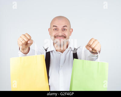 Caucasian man chauve, avec des sacs en papier colorées isolé sur fond. Banque D'Images