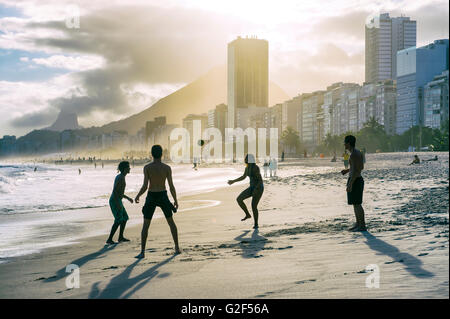 RIO DE JANEIRO - le 30 octobre 2015 : Silhouettes de Brésiliens jouent altinho beach football dans un cercle sur la plage de Copacabana. Banque D'Images