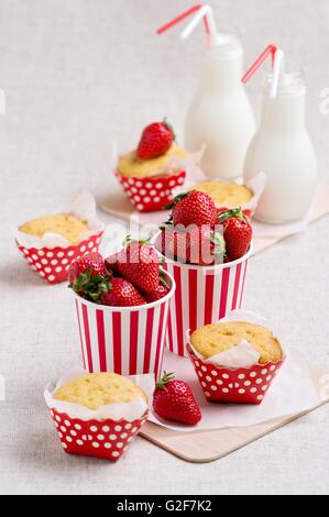 De délicieux muffins, des fraises et du lait en bouteilles. Banque D'Images