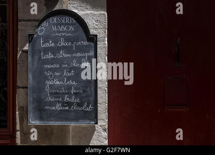 Menu bonbons tableau noir sur un mur de pierre dans une rue de France. Banque D'Images