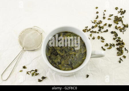 Thé vert au jasmin dans une tasse de feuilles de tissu de soie Banque D'Images