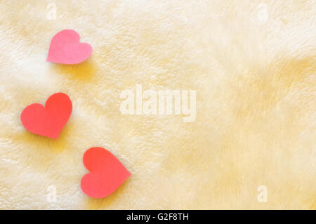 Découpe trois coeurs rouges sur fond de laine Banque D'Images