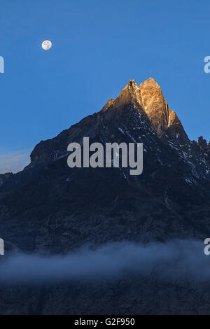 La lune et l'alpenglow sur une pointe de la neige dans l'Himalaya vu depuis le parc national de Sagarmatha au Népal. Banque D'Images