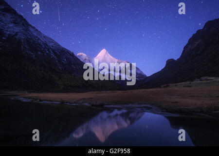Dans l'aube de Yading national nature reserve, dans la province de Sichuan de Chine, un météore Orionid Jampayan steaks sur le Banque D'Images