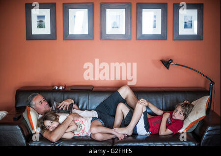 Père de détente sur table avec deux enfants Banque D'Images