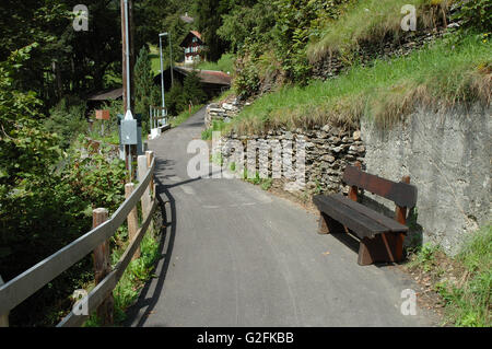 Grindelwald, Suisse - le 19 août 2014 : tarmac étroit sentier et banc en bois à Grindelwald en Suisse. Des inconnus Banque D'Images