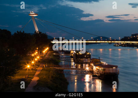 Vue sur le pont du Soulèvement national slovaque (OVNI ou pont). Danube avec reflets. Ciel coucher de soleil nuageux. Banque D'Images