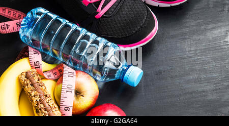 Les fruits, bouteille d'eau, barre de céréales et des baskets, sport itmes, mode de vie sain Banque D'Images