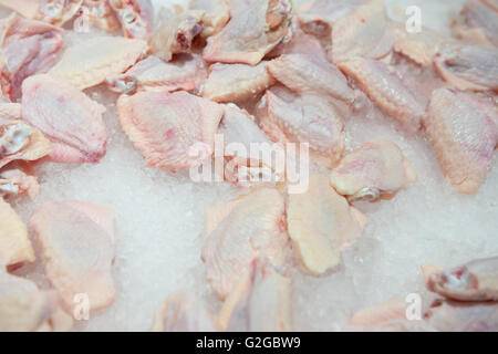 Ailes de poulet crues sur le dessus de la glace sur la vente au surpermarket Banque D'Images