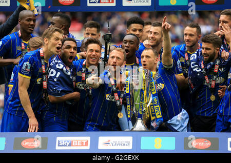 L'AFC Wimbledon's Sean Rigg (centre) et ses coéquipiers célèbrent avec le trophée après son côté gagne le pari du Ciel deux Play-Off ligue match de finale au stade de Wembley, Londres. Banque D'Images