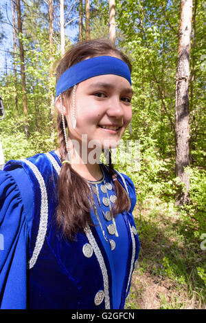 Young Girl smiling portant un costume traditionnel russe bleu Banque D'Images