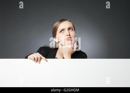 Perplexe businesswoman looking up Banque D'Images