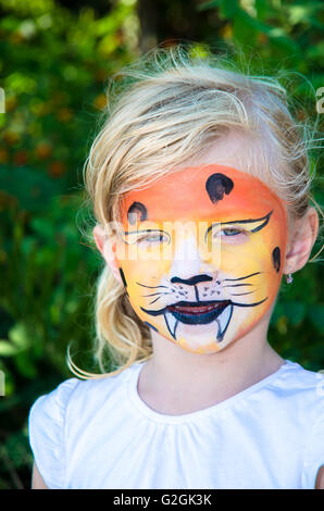 Belle fille blonde avec tiger face painting Banque D'Images