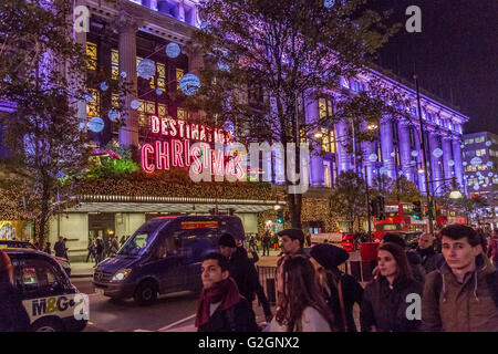 Les amateurs de Noël se promo dans Oxford Street à Londres, passant devant le grand magasin Selfridges, Londres, Royaume-Uni Banque D'Images