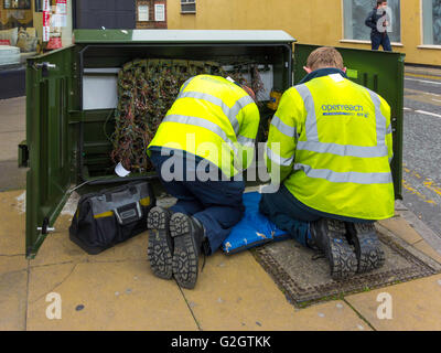 Deux techniciens des télécommunications BT Openreach travaillant sur une armoire dans un centre-ville Banque D'Images