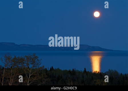 Lune se levant au-dessus du lac Supérieur à la tombée de la Thunder Bay Ontario Canada Banque D'Images