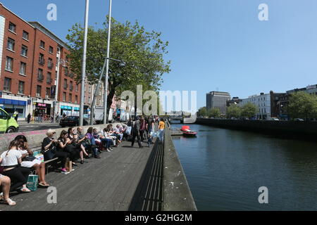 Dublin, Irlande. 30 mai, 2016. Se détendre sur la promenade le long de la rivière Liffey, dans le centre-ville de Dublin au cours d'une période d'ensoleillement et des températures élevées. Profitez de la période des Dubliners températures plus chaudes que dans la capitale irlandaise. Credit : Brendan Donnelly/Alamy Live News Banque D'Images