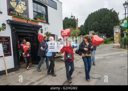 Harmondsworth, Londres, Royaume-Uni. 30 mai, 2016 HACAN et anti-3ème campagne en piste d'Harmondsworth "célébrer" le 70e anniversaire d'Heathrow avec '70 Pas de 3ème piste' ballons et plus de 750 avions noirs sur le village vert, représentant le nombre de maisons qui seront détruites. Les gens à pied des 5 cloches en forme de cœur comptable Pub ballons à l'hélium avec le message "Pas de nouvelle piste d'. Crédit : Peter Marshall/Alamy Live News Banque D'Images