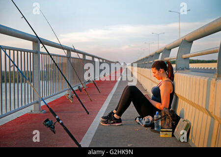 (160531) -- BELGRADE, 31 mai 2016 (Xinhua) -- une jeune fille poissons et entre-temps bénéficie d'coucher du soleil à Pupin Bridge à Belgrade, en Serbie, le 23 mai. 2016. Le Pont, nommé d'après le scientifique et inventeur serbe Mihajlo Pupin, a été ouverte par le Premier Ministre de la République populaire de Chine Li Keqiang et son homologue serbe Aleksandar Vucic, le 18 décembre 2014. Comme le deuxième pont sur le Danube à Belgrade, il a terminé l'histoire que pour 70 ans il y avait seulement un pont de Belgrade sur le Danube. Connexion de Zemun au sud de Danube et roman sur le nord, le pont a raccourci le billet tim Banque D'Images