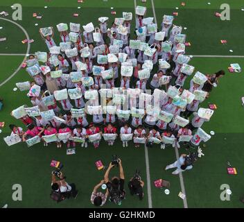 Chongqing. 31 mai, 2016. Les élèves du primaire montrent leurs oeuvres d'art sur des sacs respectueux de l'environnement au cours d'un événement de peinture pour célébrer la Journée de l'enfance et promouvoir la sensibilisation de la protection de l'environnement dans le sud-ouest de la municipalité de Chongqing en Chine, le 31 mai 2016. © Chen Cheng/Xinhua/Alamy Live News Banque D'Images